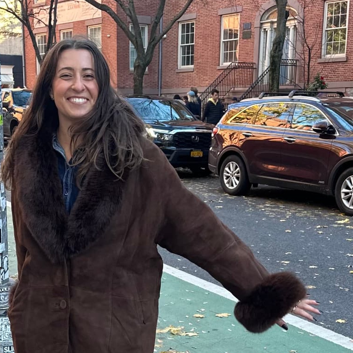 Sarah, founder of Hobbee Club, smiling on a New York City sidewalk