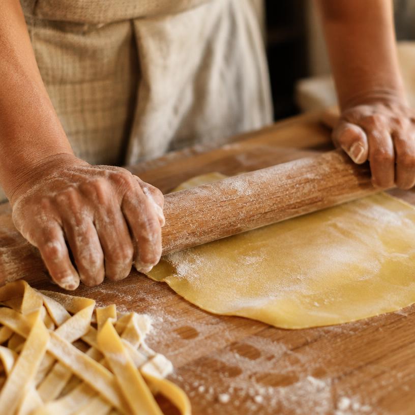 Floury hands rolling fresh pasta